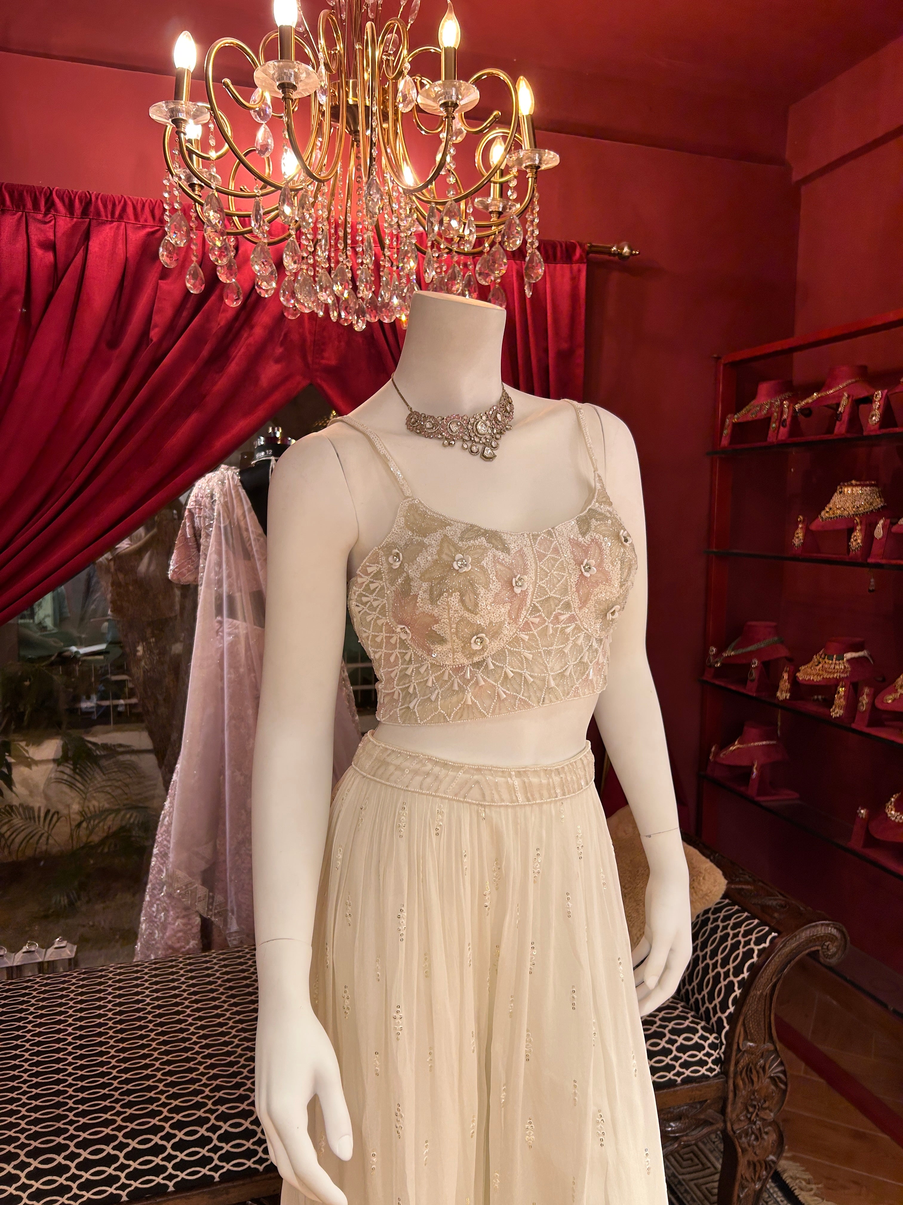 Sober white spaghetti-strap crop choli with asymmetrical shrug.