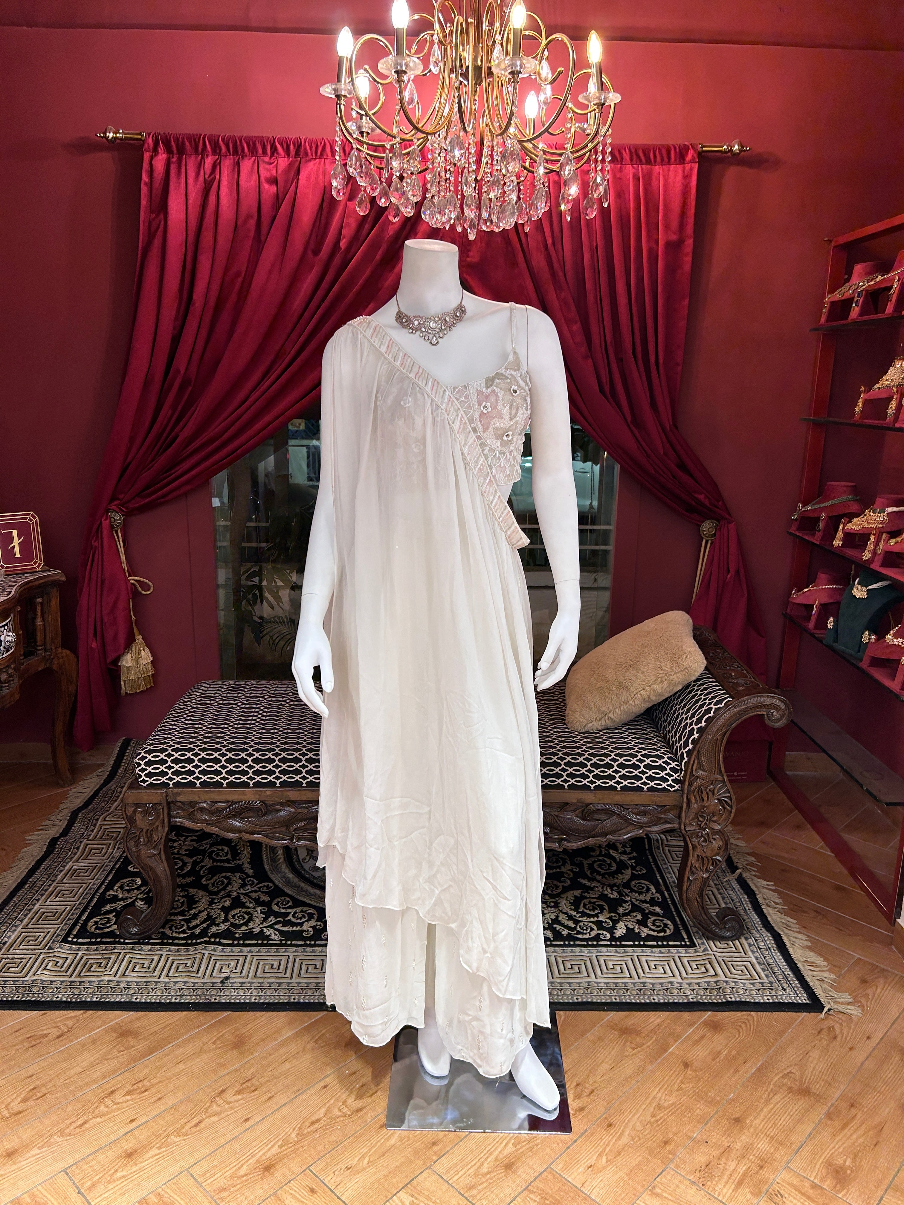 Sober white spaghetti-strap crop choli with asymmetrical shrug.