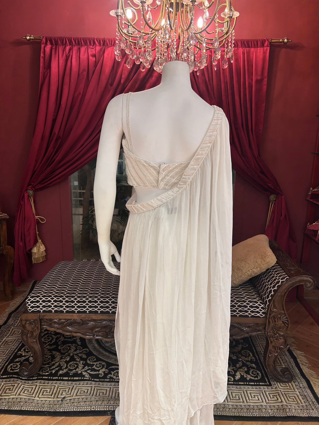 Sober white spaghetti-strap crop choli with asymmetrical shrug.